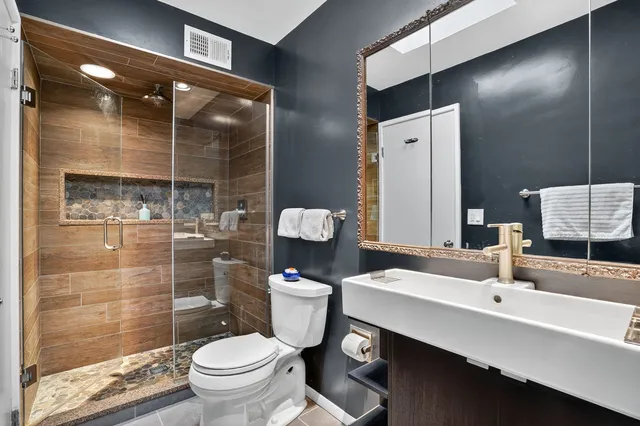 a bathroom with a sink a toilet and shower