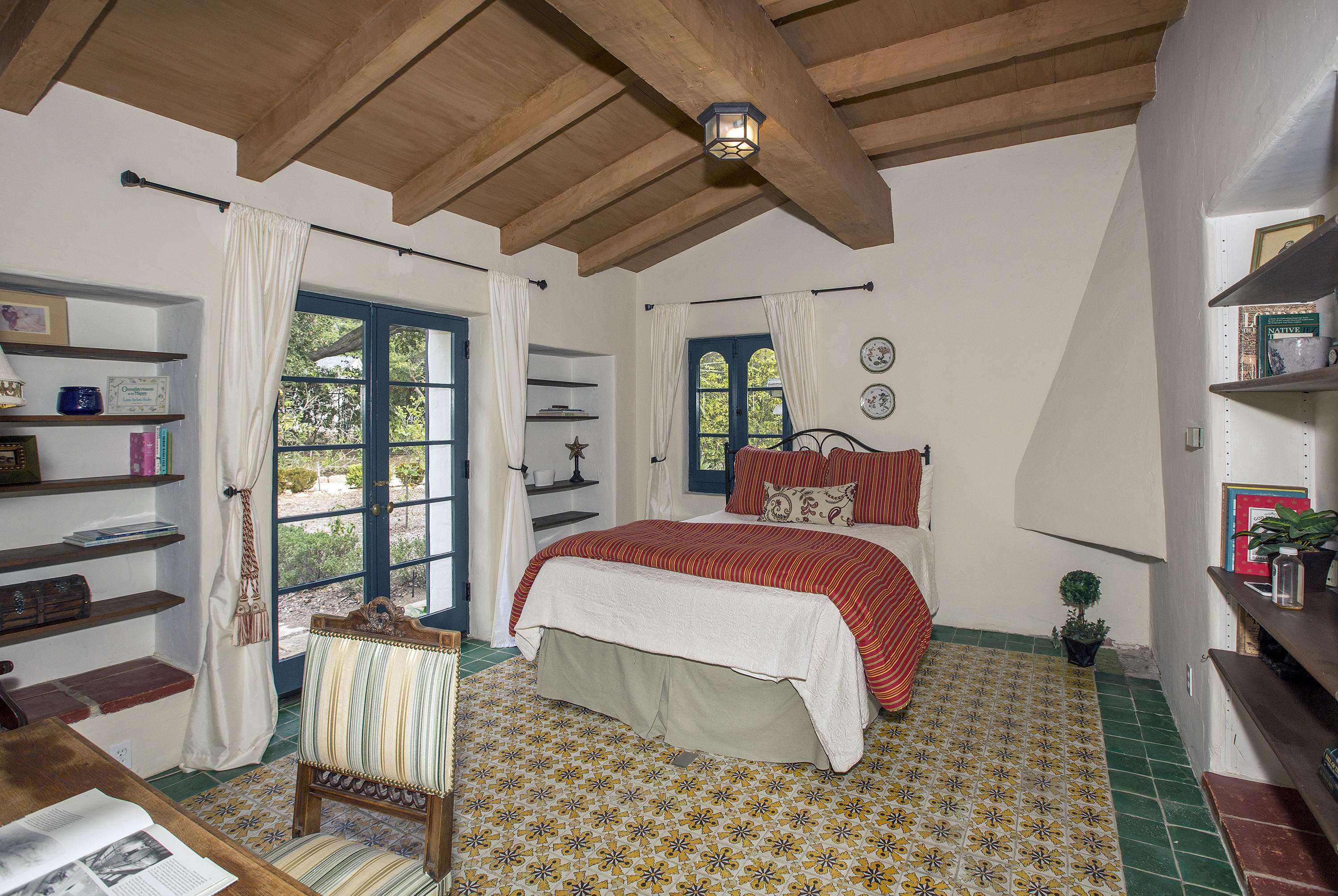 1919 Las Tunas Road Santa Barbara, CA 93103 - Photo 18 of 27 a bedroom with a bed a flat screen tv and a bookshelf