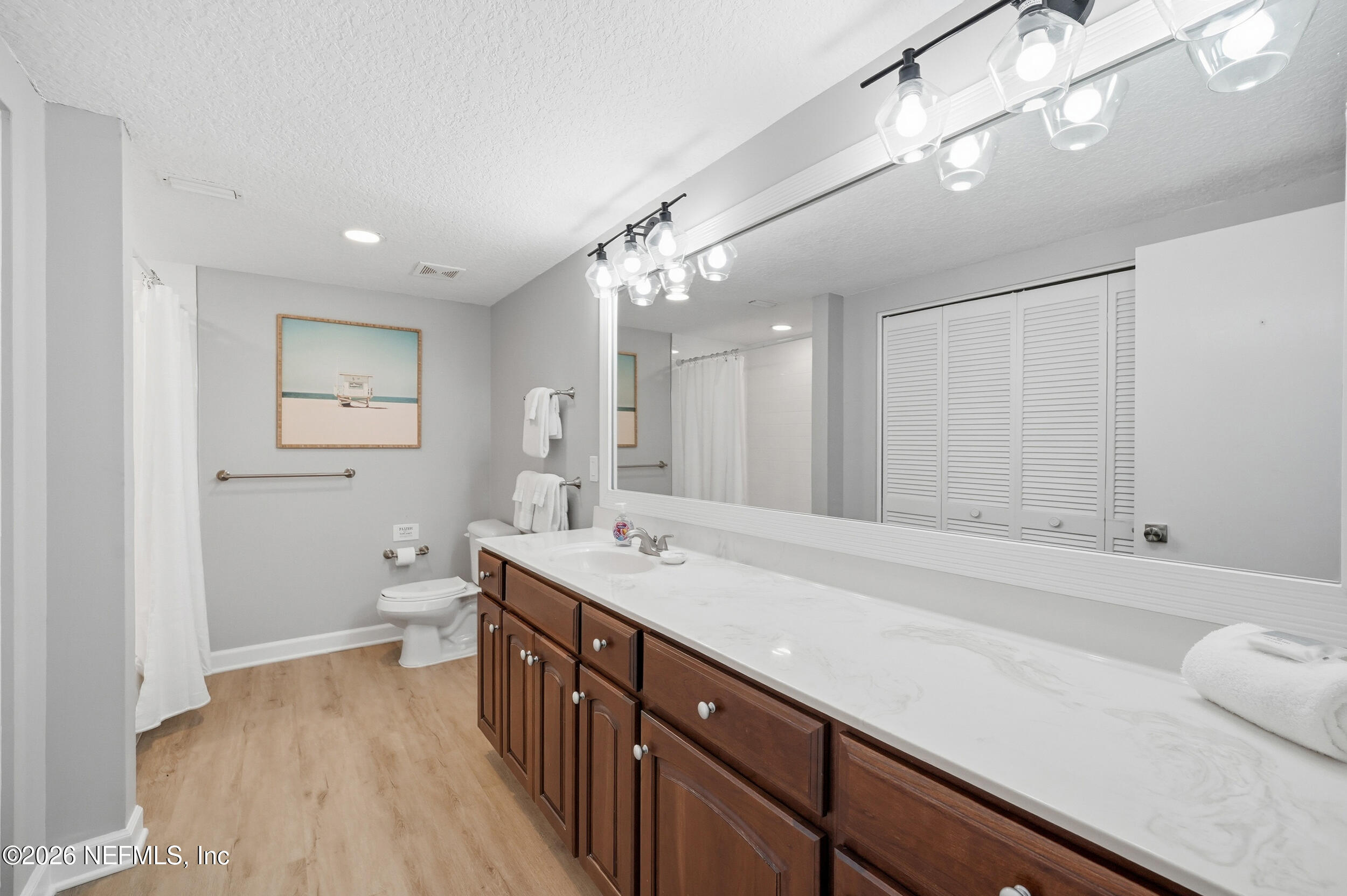 1817 Turtle Dunes Place Fernandina Beach, FL 32034 - Photo 24 of 34 a spacious bathroom with a granite countertop sink a toilet a mirror and shower