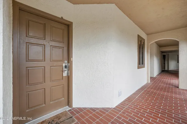 a view of a hallway with wooden floor and closet