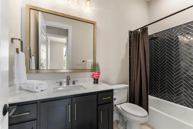 a bathroom with a sink toilet vanity and shower