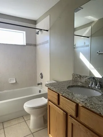 a bathroom with a granite countertop sink a toilet and shower