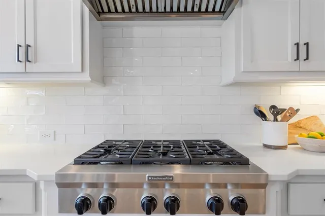 a large white kitchen with lots of counter space and chandelier