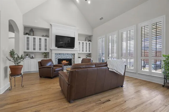 a living room with furniture a flat screen tv and a fireplace
