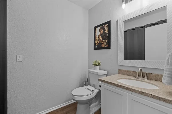 a bathroom with a granite countertop sink toilet and a mirror