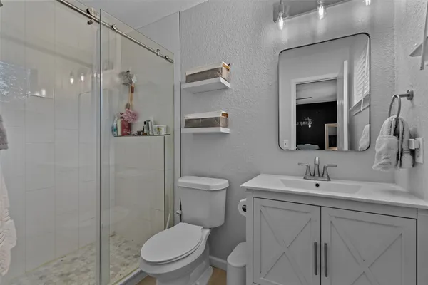 a bathroom with a toilet sink vanity and mirror