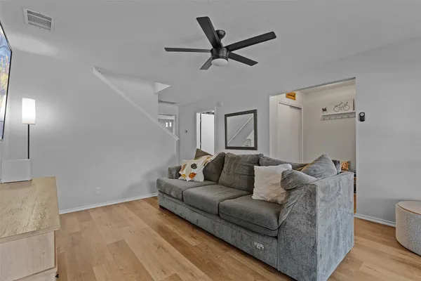 a living room with furniture and a wooden floor