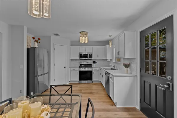 a kitchen with stainless steel appliances a stove a sink and a refrigerator