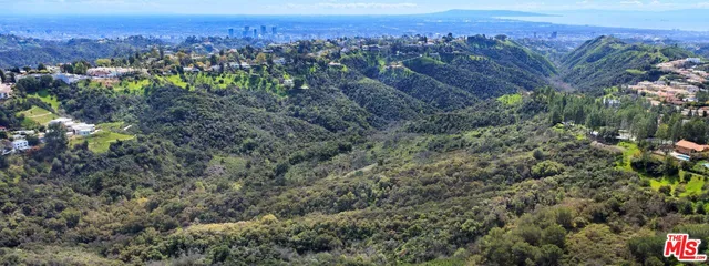 an aerial view of a houses with a lush green hillside