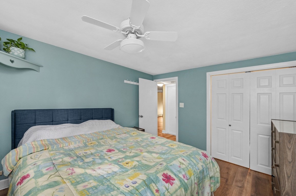 68 Preston Street, Unit 5F Wakefield, MA 01880 - Photo 13 of 20 a bedroom with a bed and a chandelier