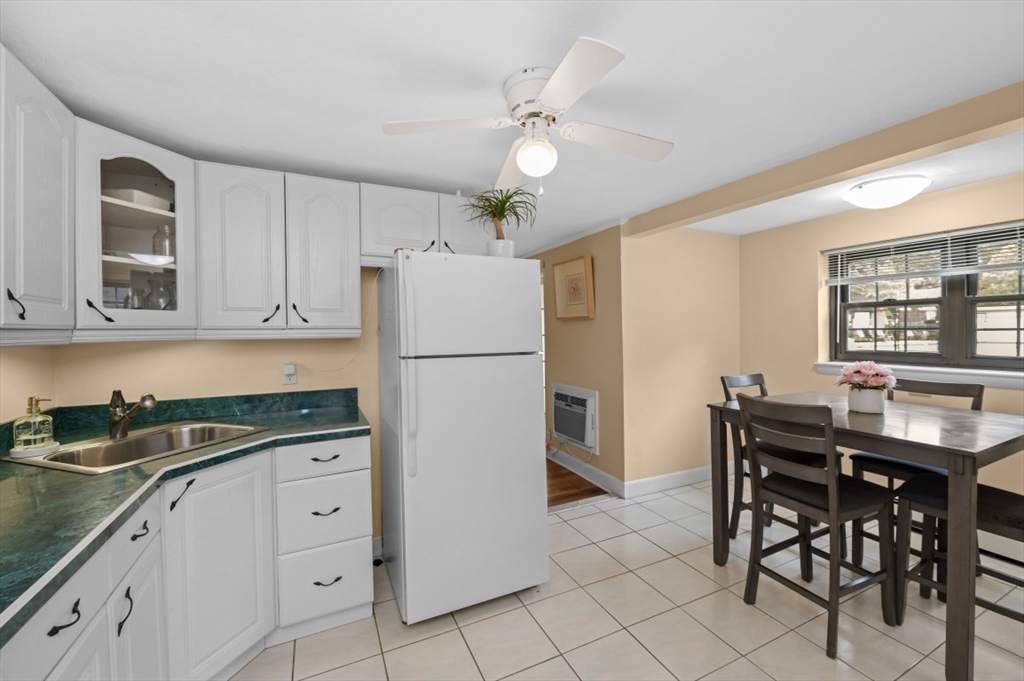 68 Preston Street, Unit 5F Wakefield, MA 01880 - Photo 4 of 20 a kitchen with a table chairs refrigerator and cabinets