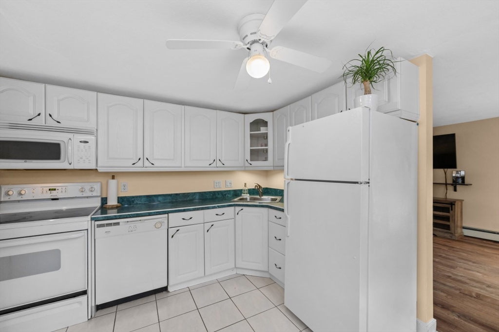68 Preston Street, Unit 5F Wakefield, MA 01880 - Photo 5 of 20 a kitchen with white cabinets and white appliances