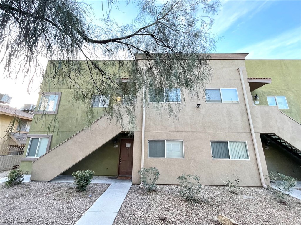 1834 North Decatur Boulevard, Unit 204 Las Vegas, NV 89108 - Photo 17 of 17 A well-maintained multi-unit residence with external stair access, set against a clear sky.