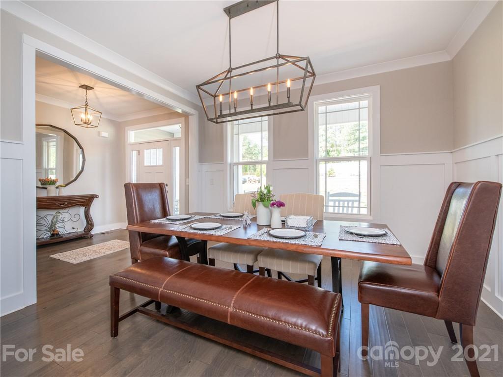 763 Red Spruce Road York, SC 29745 - Photo 13 of 43 a dining room with wooden floor a chandelier a wooden table and chairs