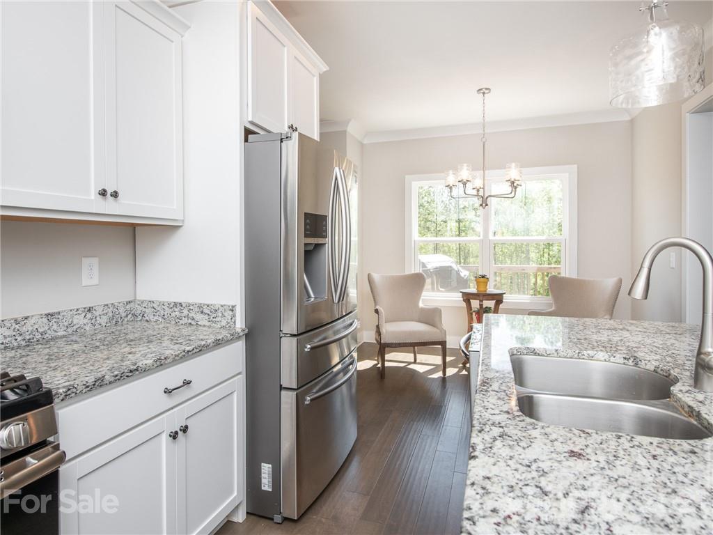 763 Red Spruce Road York, SC 29745 - Photo 16 of 43 a kitchen with stainless steel appliances granite countertop a refrigerator a stove a sink and white cabinets with wooden floor