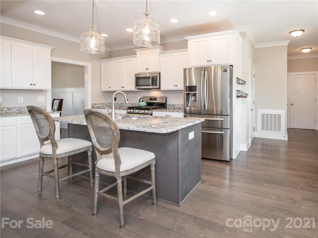 763 Red Spruce Road York, SC 29745 - Photo 3 of 43 a kitchen with stainless steel appliances kitchen island granite countertop a table chairs and a refrigerator