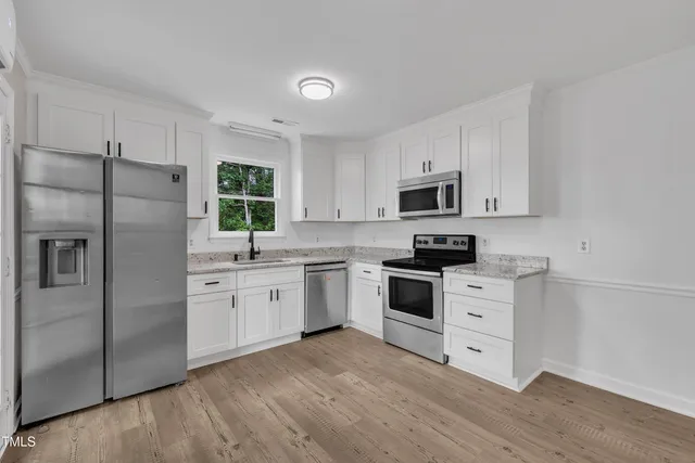 a living room with furniture a flat screen tv and a window