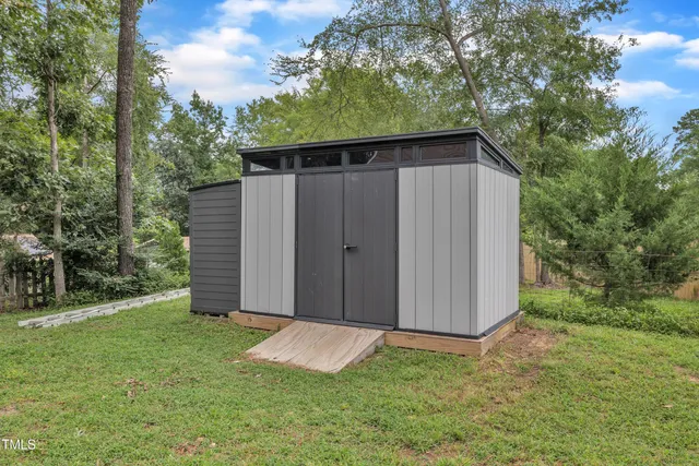 a view of a brick house with a large trees