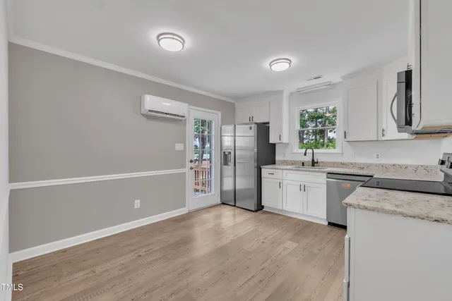 a view of an empty room with a window and wooden floor