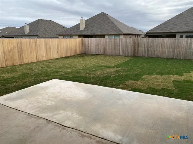 a backyard of a house with lots of green space and lake view