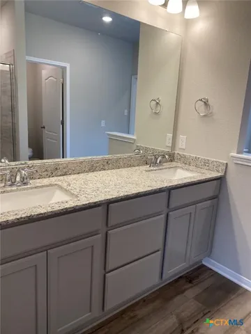 a bathroom with a granite countertop sink and a mirror