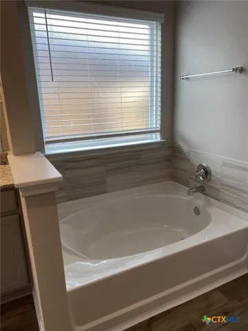 a bathroom with a bathtub and a window