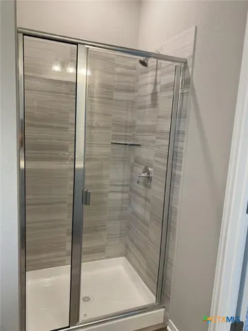 a bathroom with a glass shower door