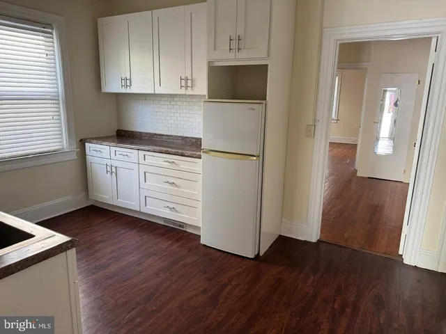a kitchen with a refrigerator and a stove top oven
