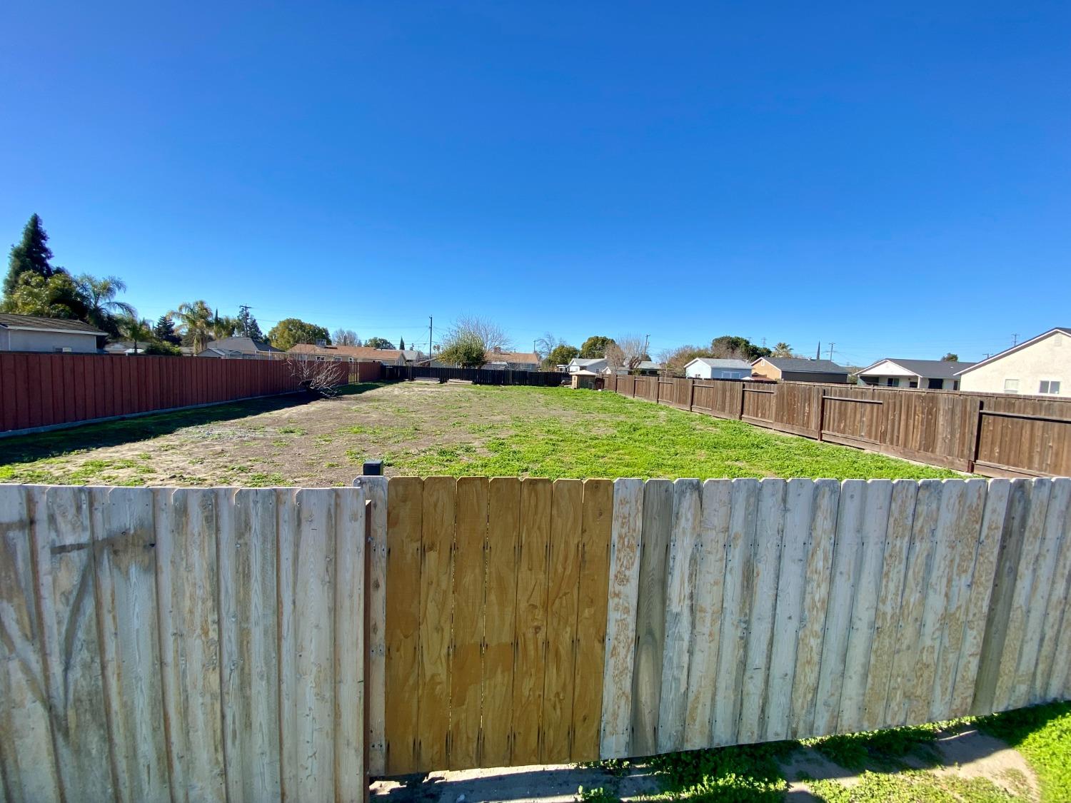 a view of a backyard with a wooden fence
