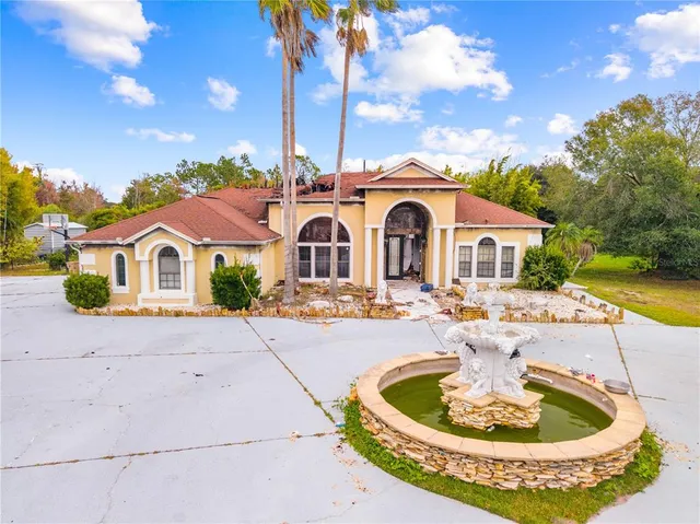 a front view of house with yard and trees in the background