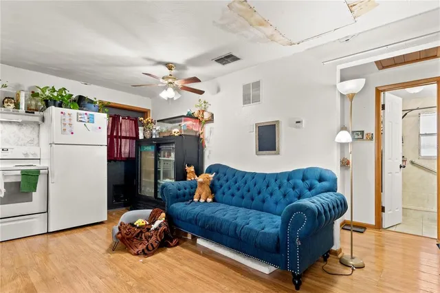 a living room with furniture a couch and a ceiling fan