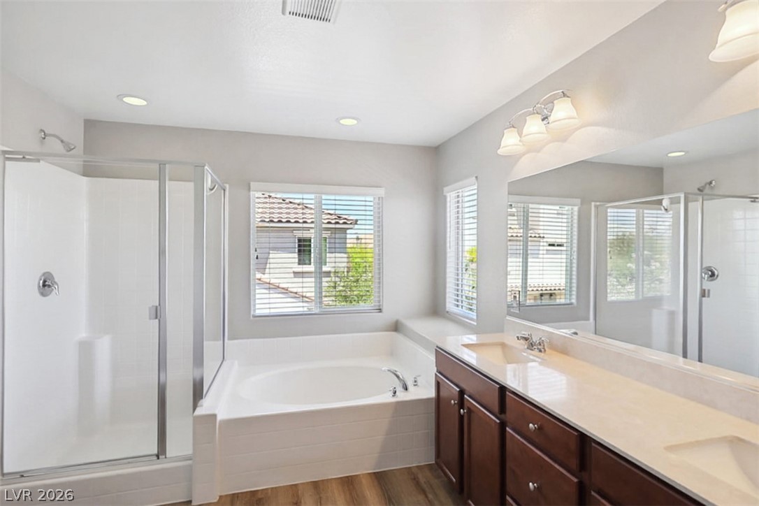 9940 Sable Point Street Las Vegas, NV 89178 - Photo 28 of 40 Full bathroom with a stall shower, a garden tub, wood finished floors, double vanity, and recessed lighting