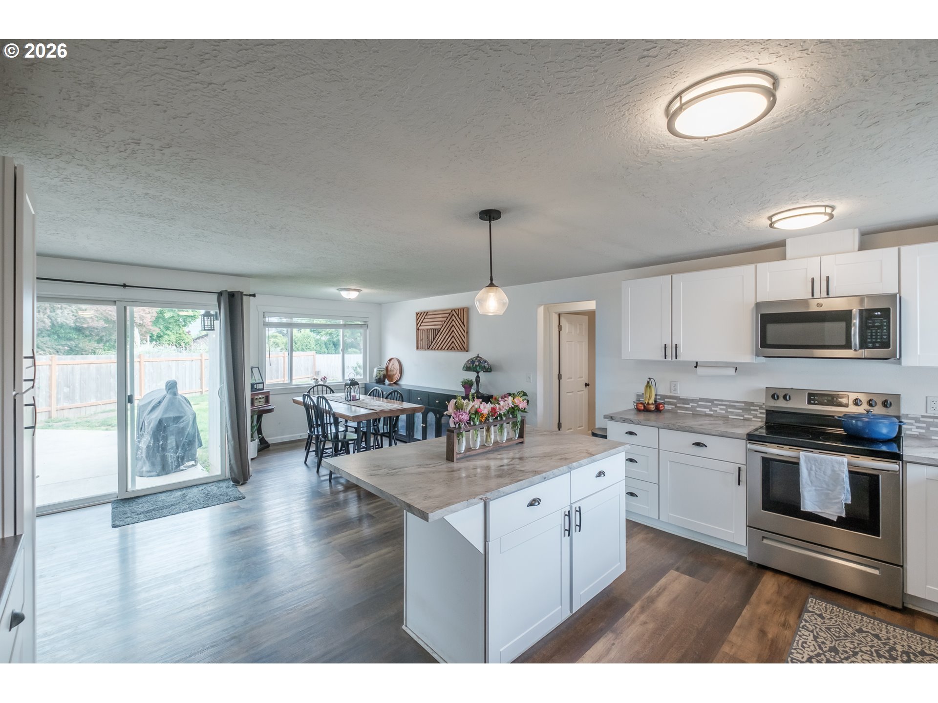 2261 Fulton Place Southeast Albany, OR 97322 - Photo 11 of 48 a kitchen with stainless steel appliances granite countertop a stove top oven a sink a dining table and chairs with wooden floor