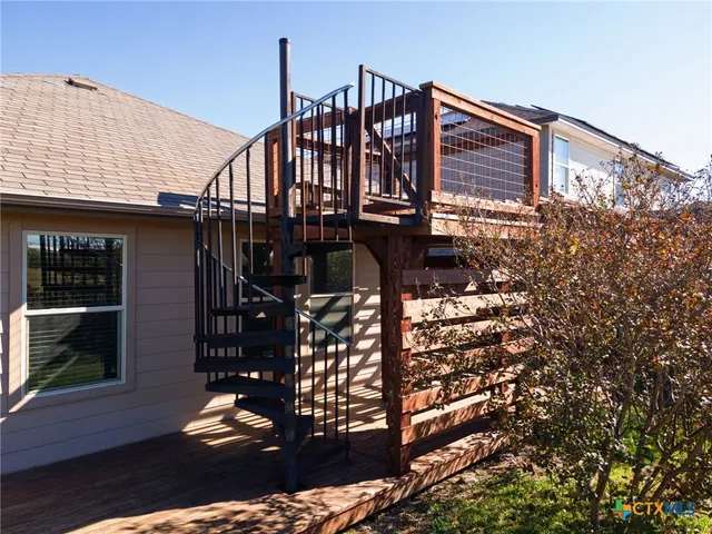 a view of a roof deck with wooden fence and a floor