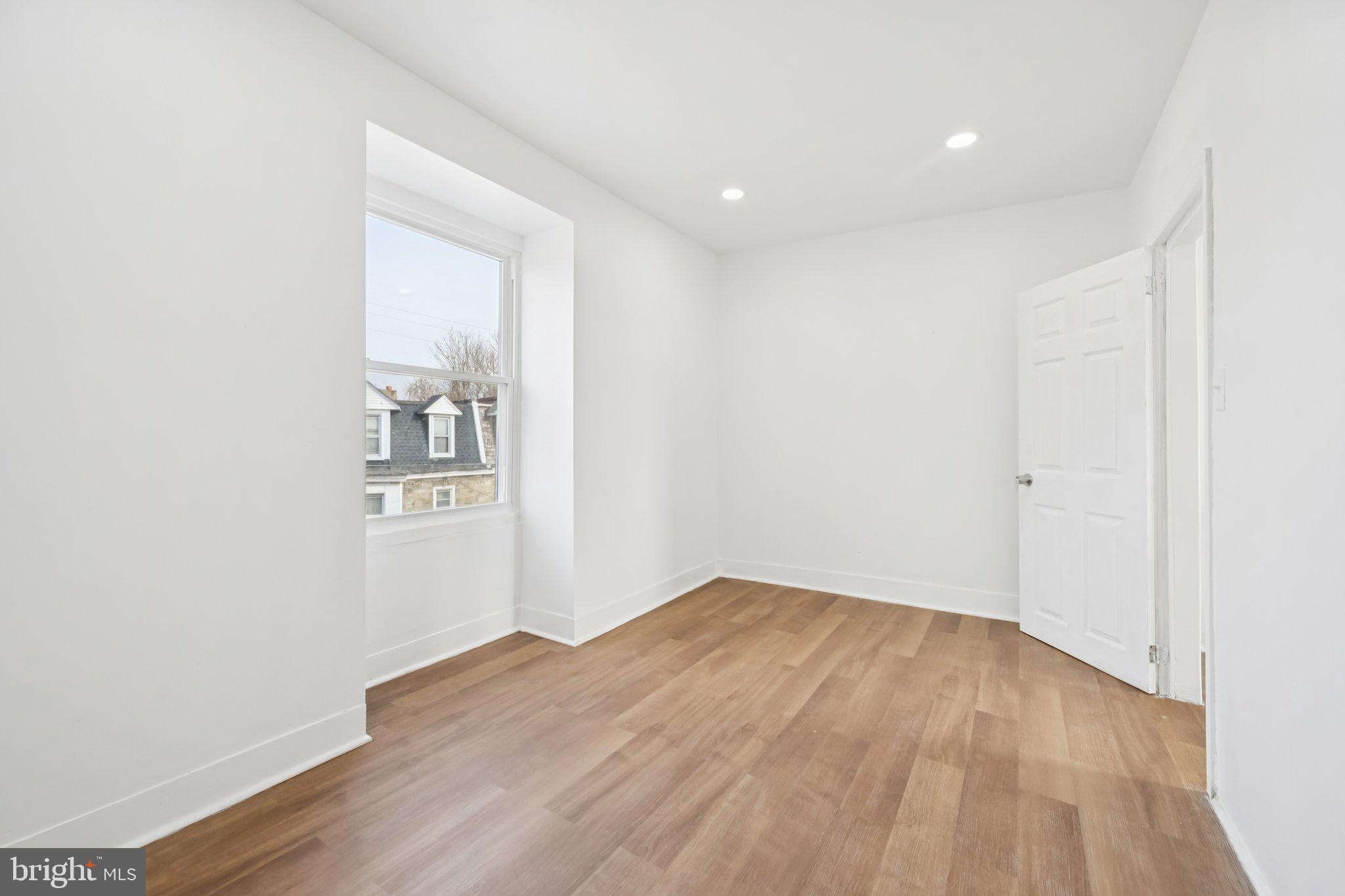 704 Main Street Darby, PA 19023 - Photo 24 of 28 an empty room with wooden floor and windows
