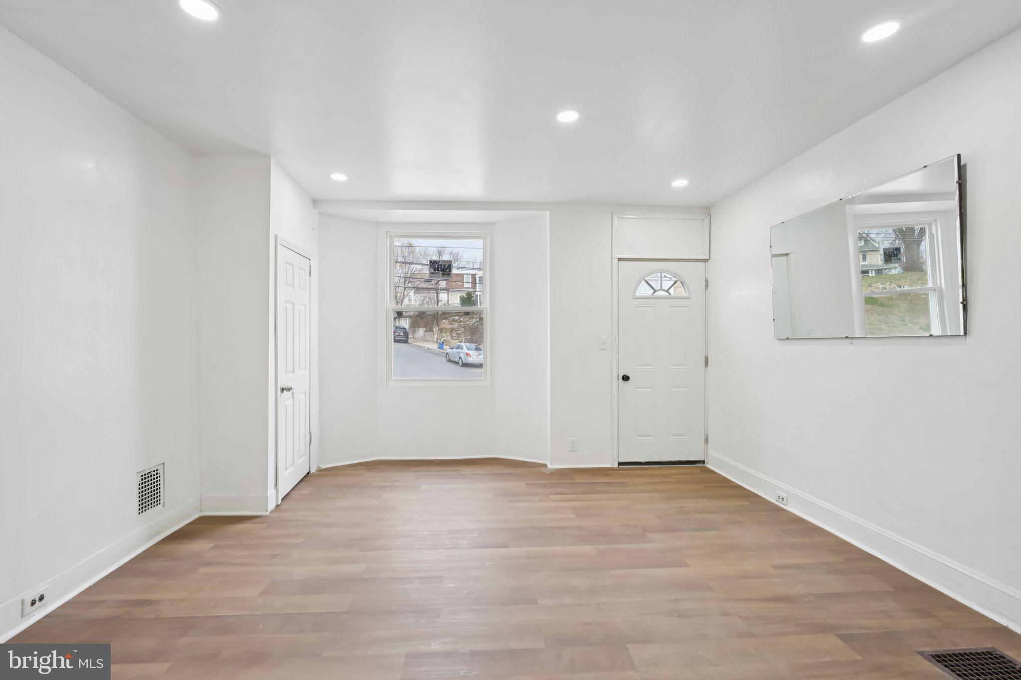 704 Main Street Darby, PA 19023 - Photo 5 of 28 an empty room with wooden floor and window