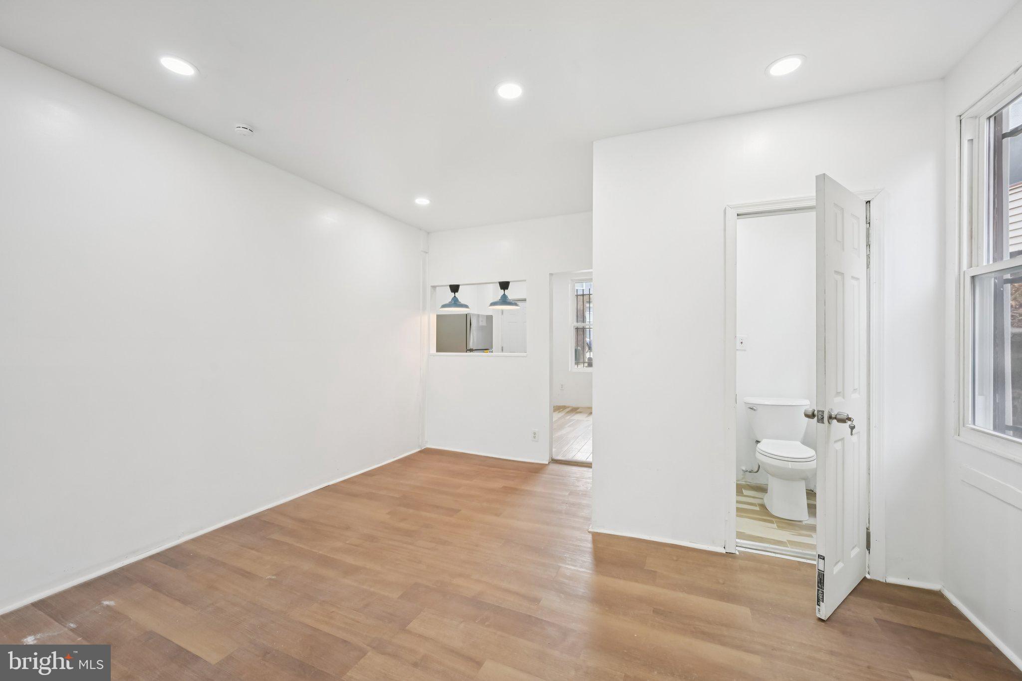 704 Main Street Darby, PA 19023 - Photo 7 of 28 an empty room with wooden floor and bathroom