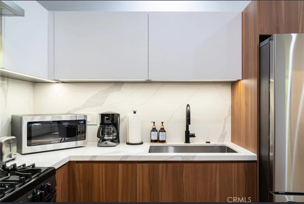 12134 Clarkson Road Los Angeles, CA 90064 - Photo 13 of 25 a kitchen with stainless steel appliances a sink a stove a microwave and refrigerator