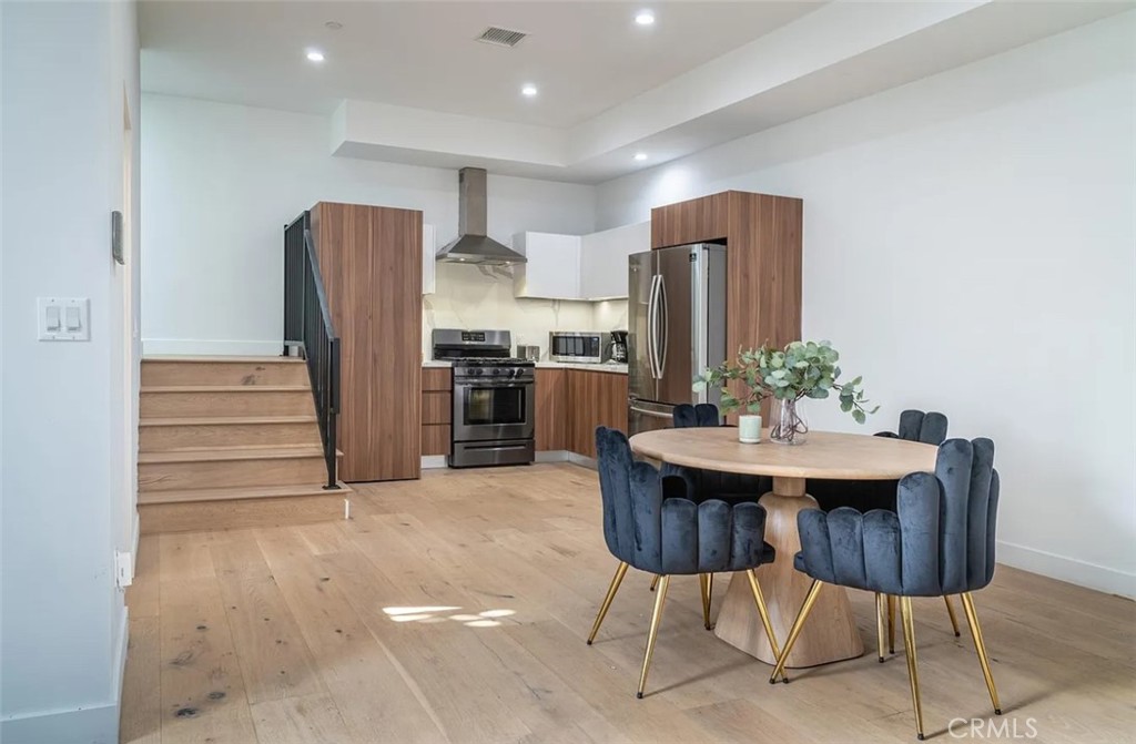 12134 Clarkson Road Los Angeles, CA 90064 - Photo 6 of 25 a kitchen with stainless steel appliances a refrigerator and a dining table