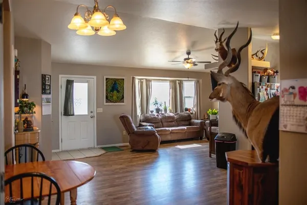 a living room with furniture wooden floor and a chandelier