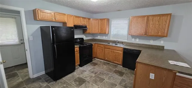 a kitchen with a sink a refrigerator and cabinets
