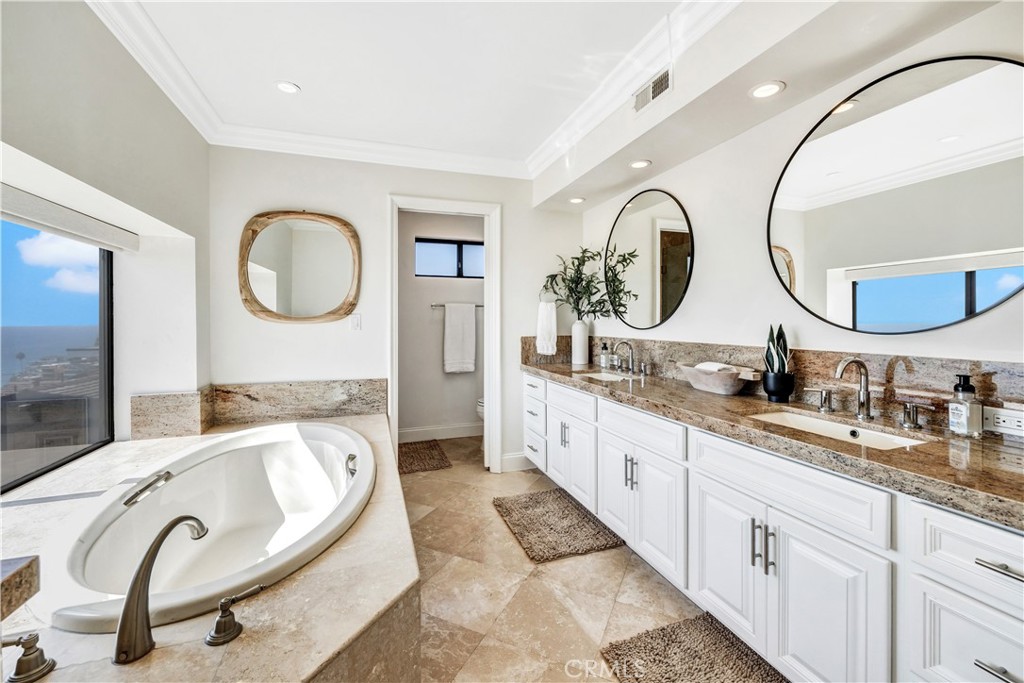 32041 Point Place Laguna Beach, CA 92651 - Photo 29 of 49 a spacious bathroom with a granite countertop double vanity and a mirror