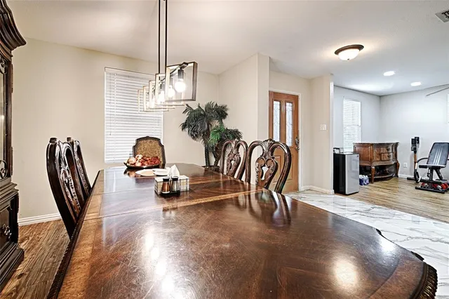a view of a dining room with furniture a chandelier and wooden floor