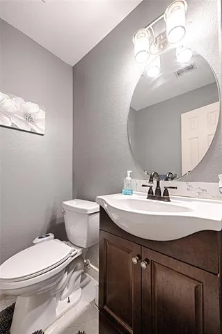 a bathroom with a sink a toilet and mirror