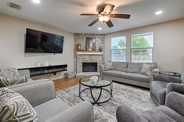 a living room with furniture a fireplace and a flat screen tv