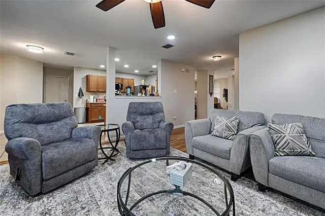 a living room with furniture kitchen view and a chandelier