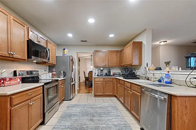 a kitchen with stainless steel appliances granite countertop a sink stove refrigerator and cabinets