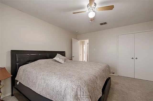 a large bed sitting in a bedroom and chandelier fan