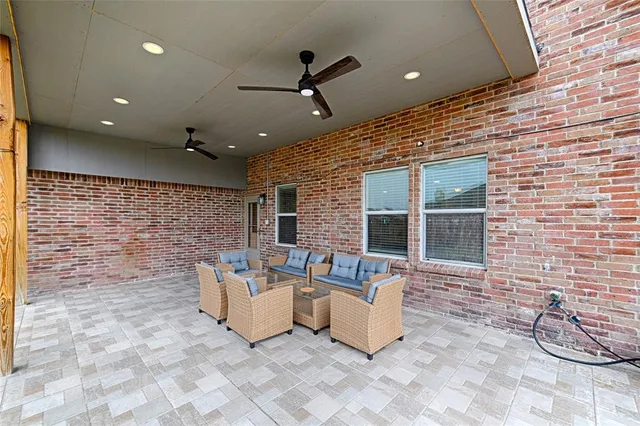 a outdoor living space with patio furniture and a ceiling fan