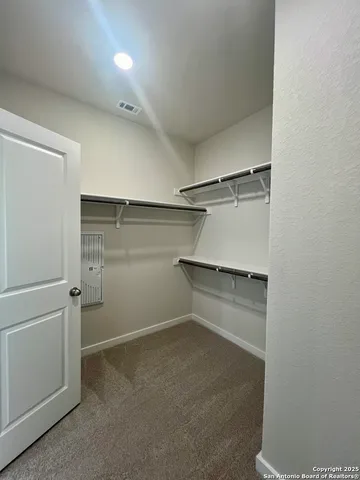 a view of a hallway with wooden floor and closet